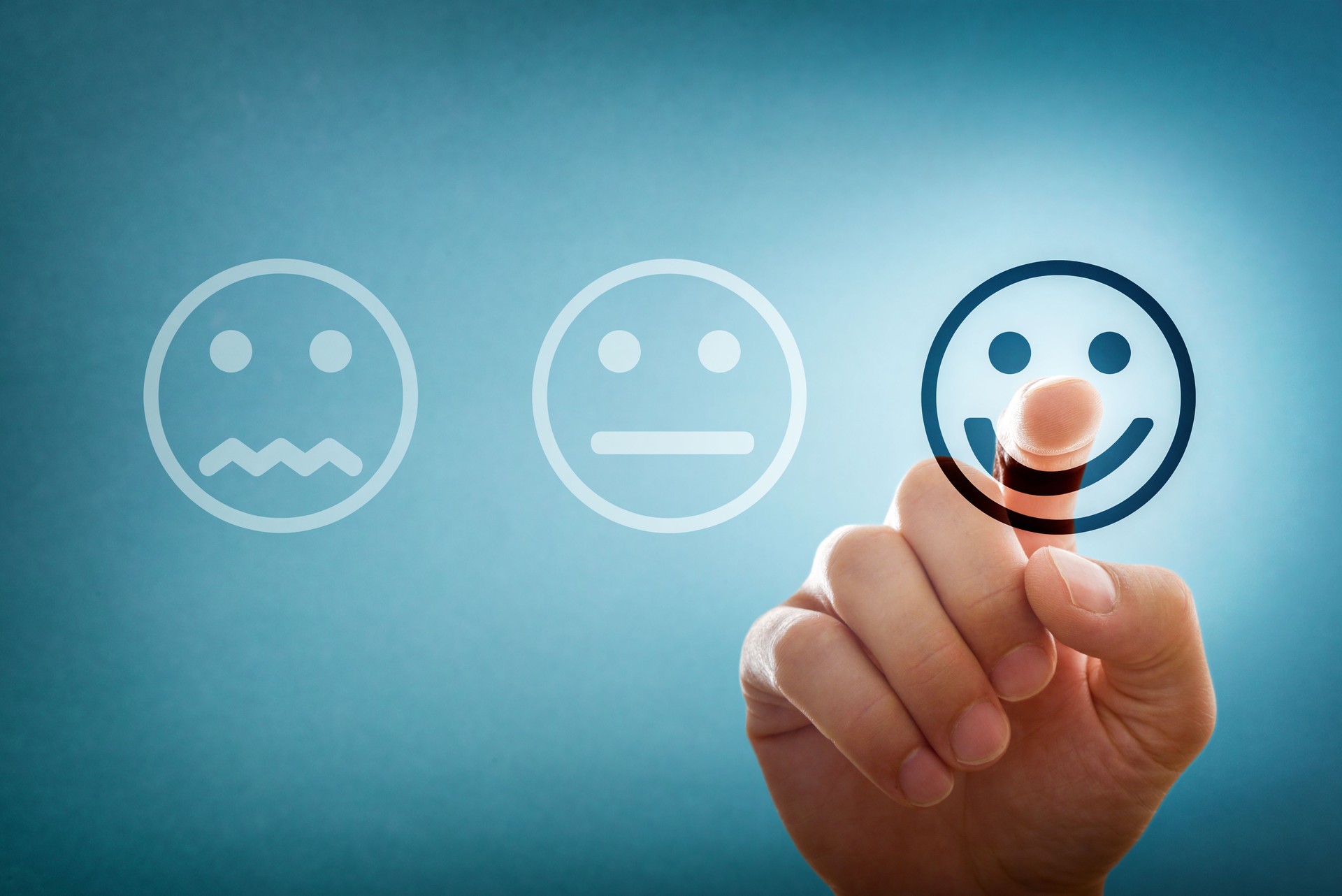 Selección a mano del emoticono feliz de tres opciones como valoración positiva